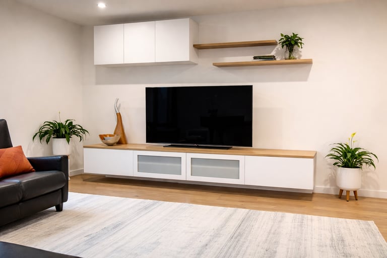 Modern white floating TV unit with wooden top and matching wall shelves in a minimalist living room.