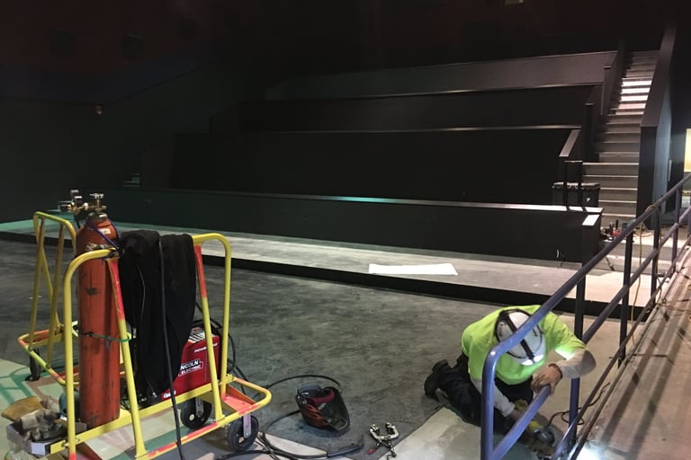 Installing powder coated movie theatre handrails Rick fabricated for Cinemark