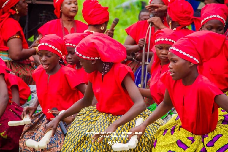 Young girls in red traditional attire performing at the Festival Createur Culture Paix in Dassa-Zoume.