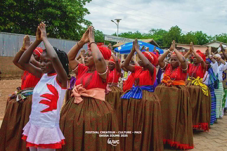 Beninese women perform a traditional dance in red and green cultural attire at the Dassa-Zoume 2025 festival.