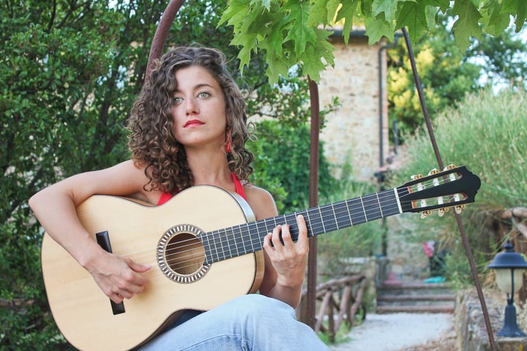 a woman with curly hair and a guitar