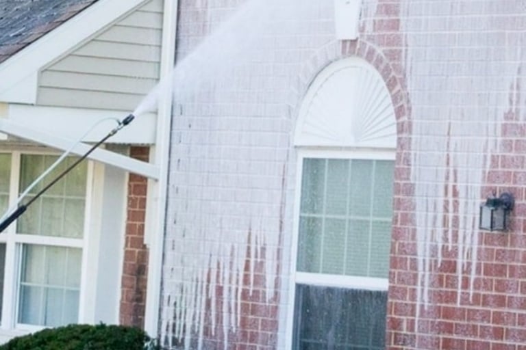 Professional soft washing service cleaning dirt from a residential brick house exterior in Vista, CA