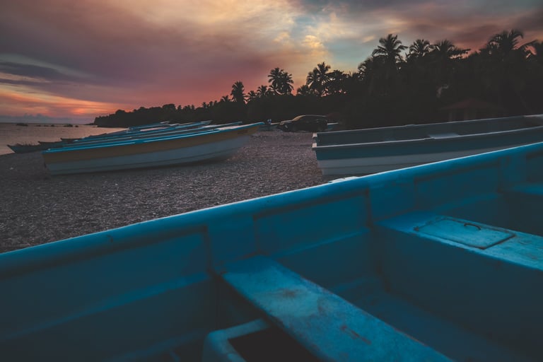 Editorial travel photograph of a coastal scene with boats at sunset, emphasizing place & atmosphere