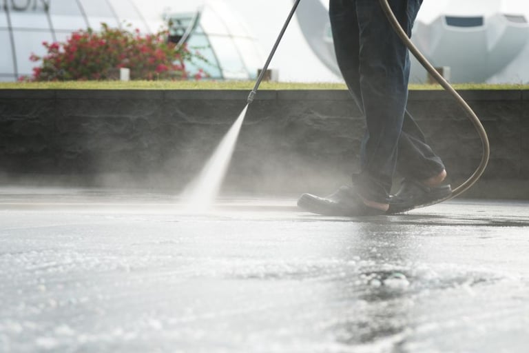 a man Pressure washing the concrete floor