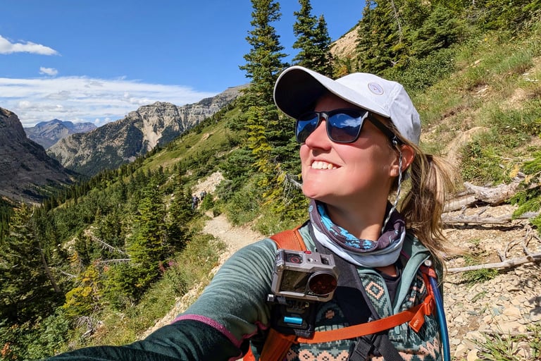 Hiker on the Crypt Lake Trail with mountain views in Waterton Lakes National Park.