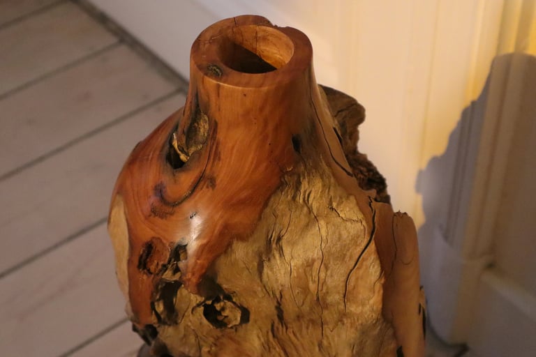 Handcrafted rustic live edge wooden vase with natural bark texture and polished grain.