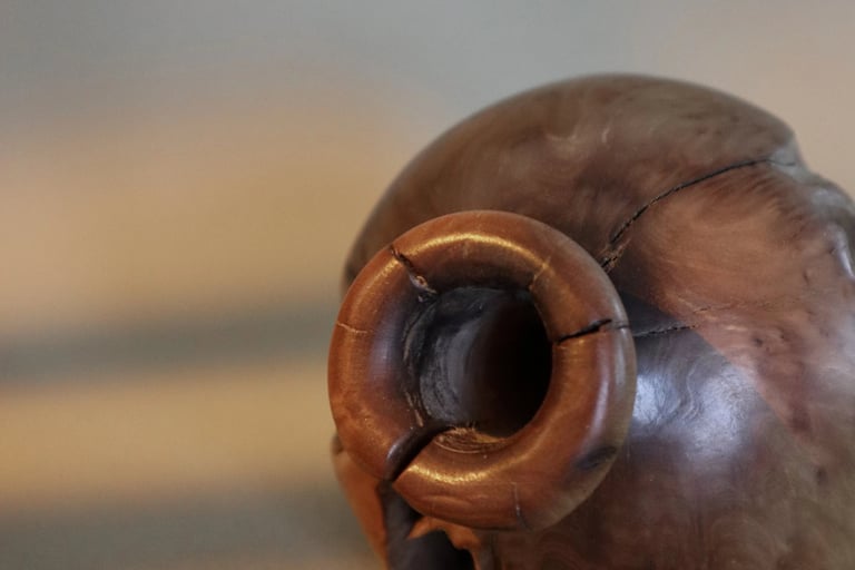 Close-up of a hand-carved decorative wooden vase with natural wood grain and rustic texture.