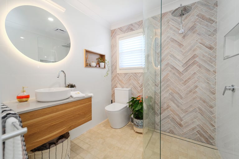 Modern private bathroom at Marche Home Stay with a floating vanity, mirror, rainfall shower, and warm natural finishes.