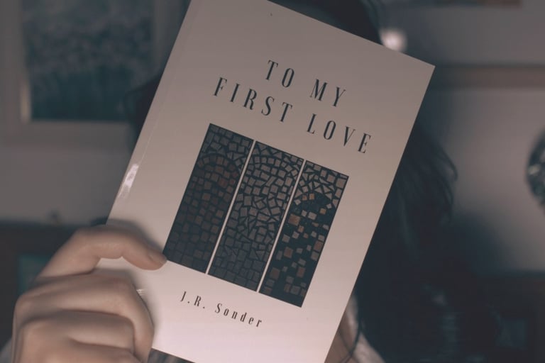 J.R. Sonder holding her book TMFL over her face.