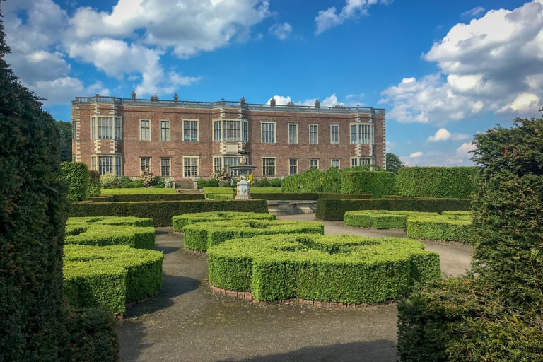 Temple newsham house, a big county house with hedge decoration in a garden, looks abit like a maze
