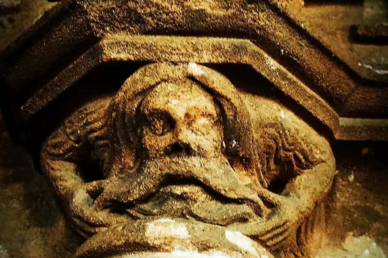 a carved figure on a stone column depicting a wild man or woodwose