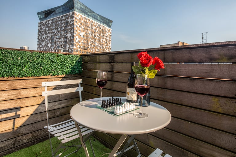 Private balcony at Birmingham B1 apartment with outdoor table, chairs and city view