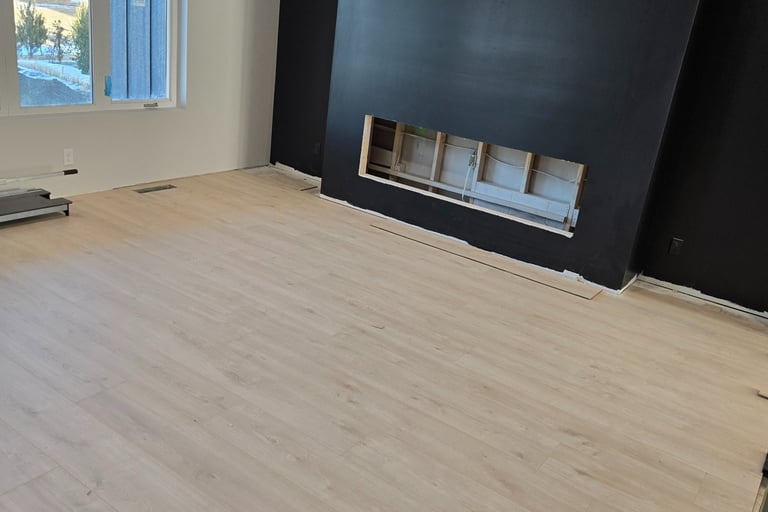 Modern living room featuring light oak laminate flooring and a black accent fireplace wall.