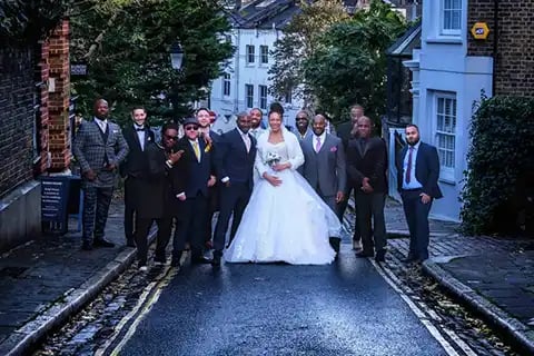 newly-weds posing on a Hampstead street with their wedding guests