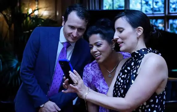 wedding guests looking at a mobile phone