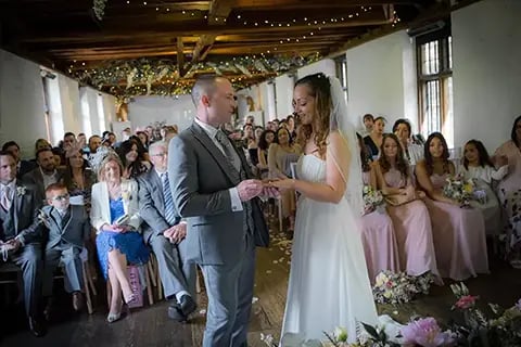 Nat and Steve standing at the front of the ceremony looking at each other