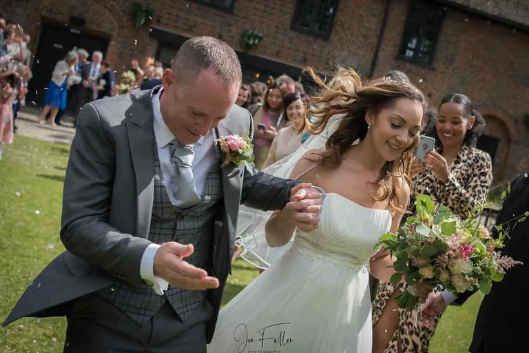 Newly-weds running through confetti