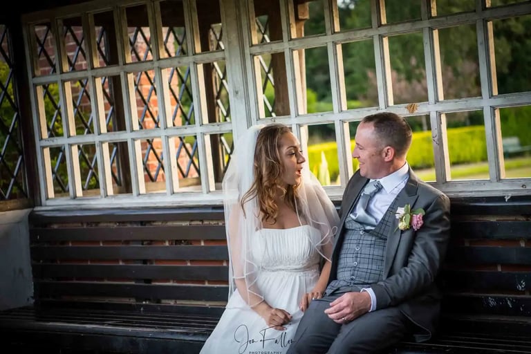 newly-weds sitting chatting on a park bench