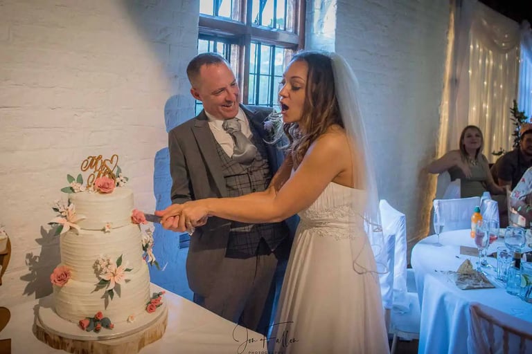 Wedding couple cutting their cake in Tudor Barn Eltham