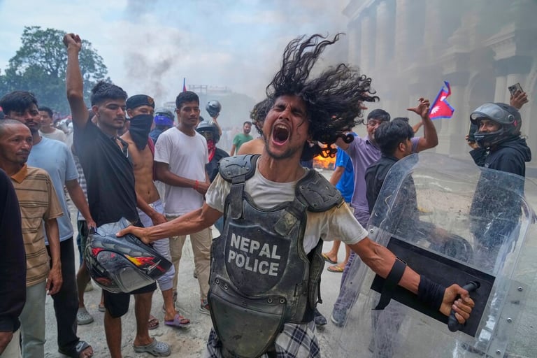A protester in Kathmandu shouts while wearing a Nepal Police riot vest during a public demonstration.