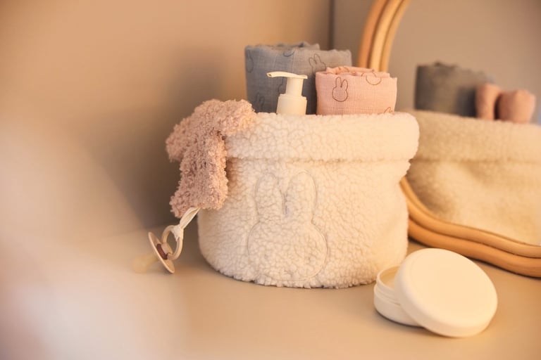 Witte fluffy Jollein Nijntje commode organizer gevuld met babyproducten op een commode