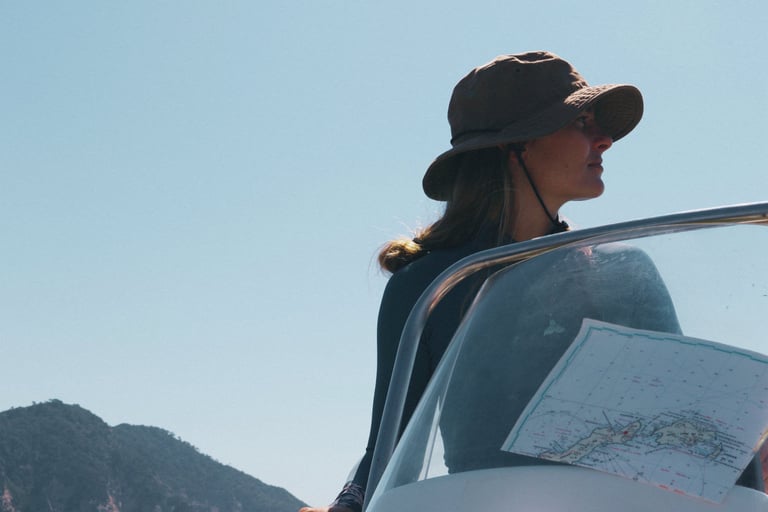 A scientist driving a boat while looking at a nautical map.