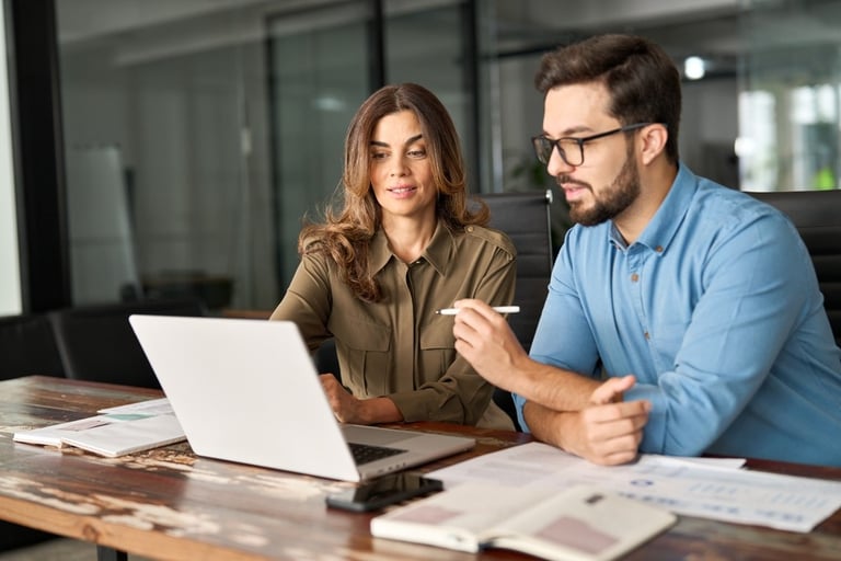 Professional man and woman sit at a table in a meeting room