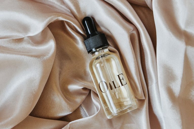 Luxury facial oil dropper bottle resting on folded champagne silk fabric.