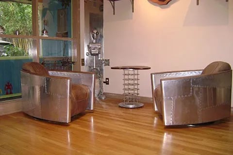 Living room with two aluminum and leather chairs and an aluminum table.