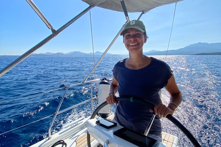 Stephanie Kabelin hat das Steuerrad in der Hand auf dem Segelboot