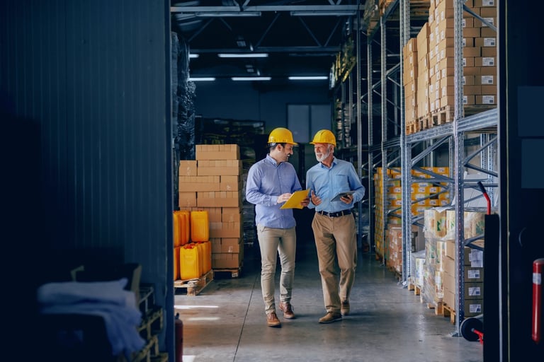 Two Men Wearing Hardhats in Warehouse