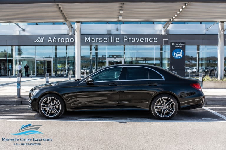 Black Mercedes sedan parked at Marseille Provence Airport for private cruise excursion transfer.
