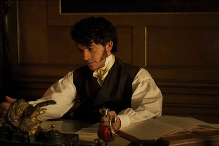 Anthony Bridgerton em seu escritório à luz de velas, escrevendo em sua mesa.