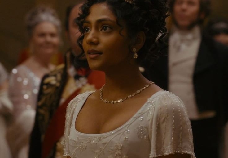Edwina Sharma usando um vestido de baile branco e tiara em Bri