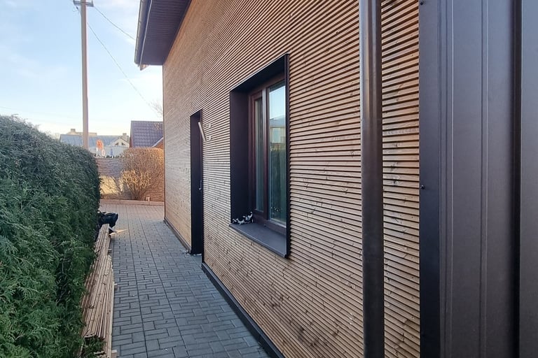 a house with a wooden siding and a brick wall