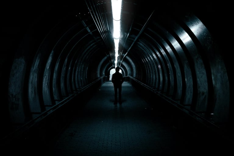 Leader walking through a dark tunnel toward the light, symbolizing early leadership transitions.