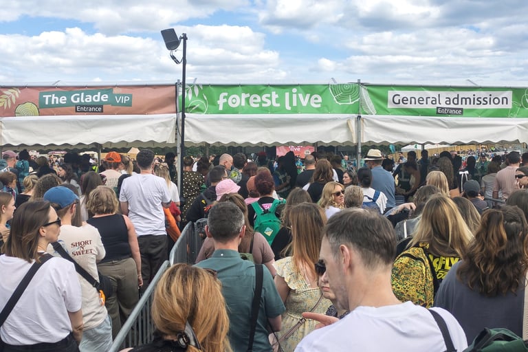 A large crowd of people queuing at the Forest Live general admission and VIP entrance gates.