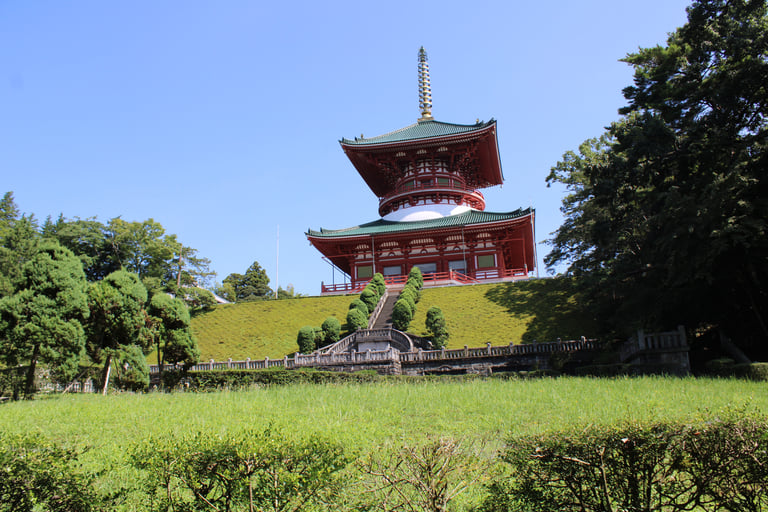 The Great Pagoda of Peace at Narita-san Shinsho-ji Temple in Japan atop a grassy hill.