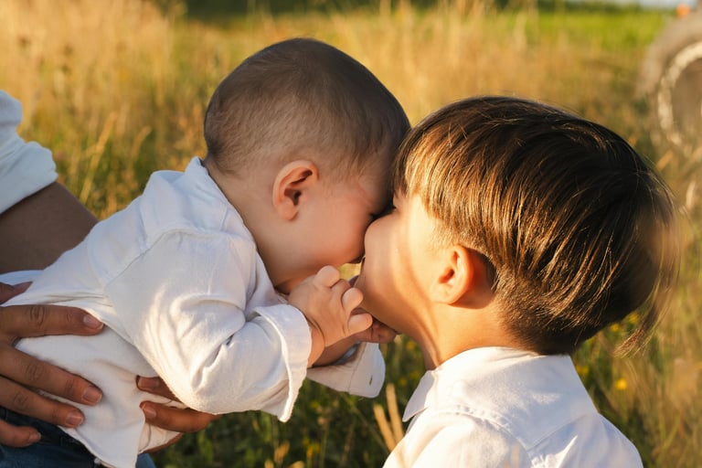a baby boy is kissing his mother's cheek