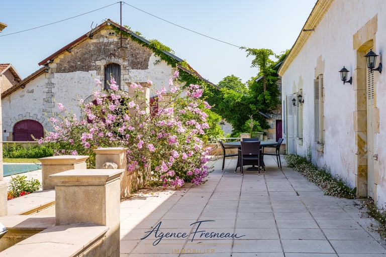 Terrasse en pierre pleine de charme avec vue sur les bâtisses du domaine, un cadre idéal.