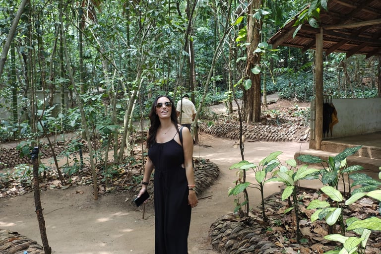 Woman in a black maxi dress walking on a jungle path at a tropical spice plantation in Goa.