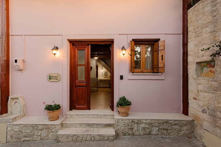Tonia's Cottage entrance door open, logo sign and purple flowers