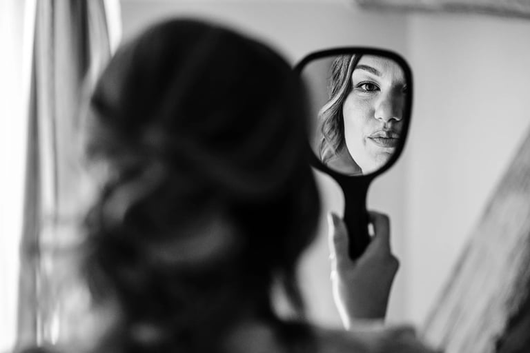 une future mariée vérifie son maquillage dans le miroir