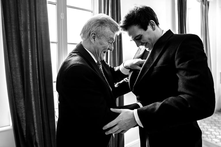 un père aide son fils à s'habiller lors du mariage