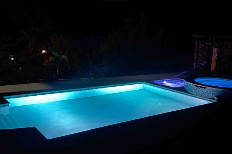 Vista nocturna con luces de la piscina de la villa presidencial Constanza