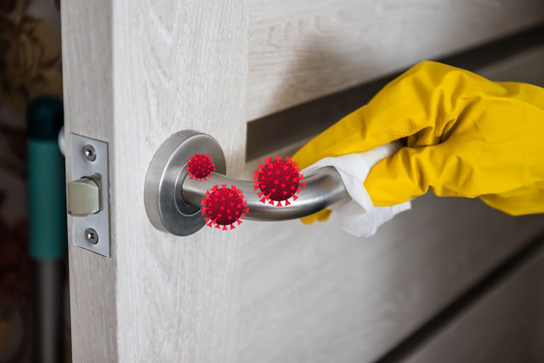 Gloved hand cleaning infected door handle