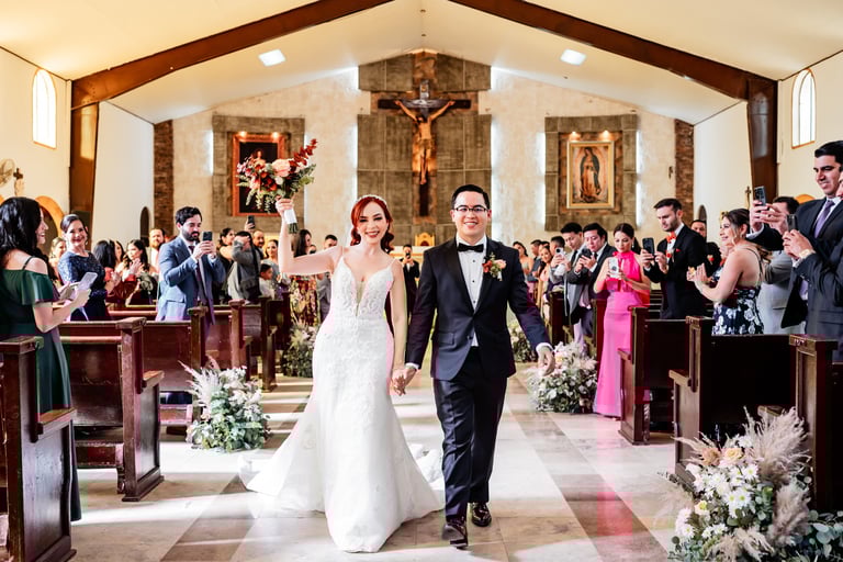 a bride and groom walking down the aisle of a church