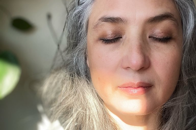 Woman with mostly white & gray hair, eyes closed