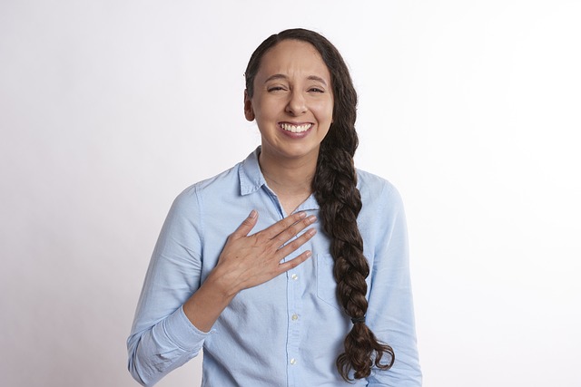  woman with braid & hand over heart, smiling