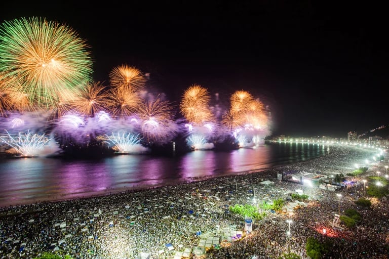 fireworks in the sky over a beach with people watching fireworks